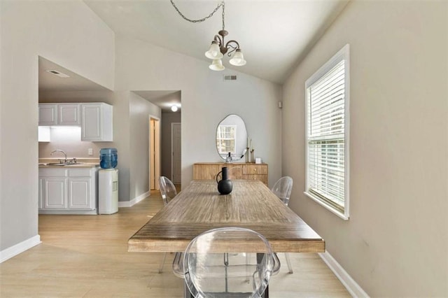 50 Emerald Hills Ln, Newnan, GA 30263 - dining area with visible vents, a chandelier, vaulted ceiling, and light wood-style floors