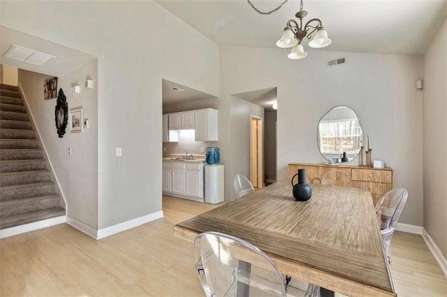 50 Emerald Hills Ln, Newnan, GA 30263 - dining room featuring visible vents, an inviting chandelier, stairs, baseboards, and light wood-type flooring