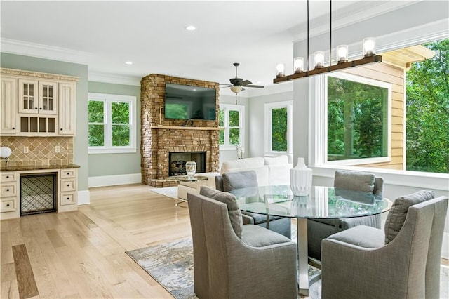 6225 Random Winds Blf, Gainesville, GA 30506 - dining area featuring ornamental molding, a fireplace, light wood-style flooring, a ceiling fan, and recessed lighting