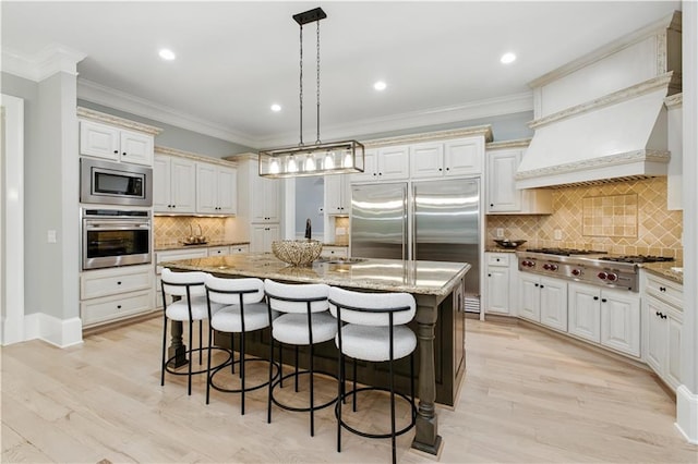 6225 Random Winds Blf, Gainesville, GA 30506 - kitchen featuring built in appliances, a center island with sink, decorative backsplash, a kitchen bar, and light stone countertops