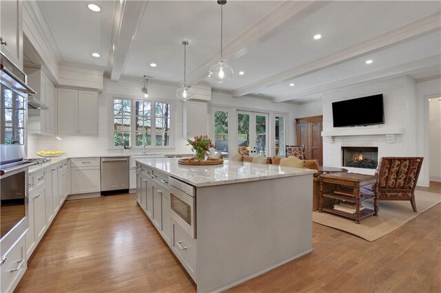 2620 Middle Coray Cir, Marietta, GA 30066 - kitchen with plenty of natural light, a kitchen island, light wood-style floors, and light stone countertops