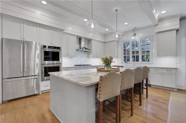 2620 Middle Coray Cir, Marietta, GA 30066 - kitchen featuring light stone countertops, beamed ceiling, light wood-style flooring, appliances with stainless steel finishes, and wall chimney range hood