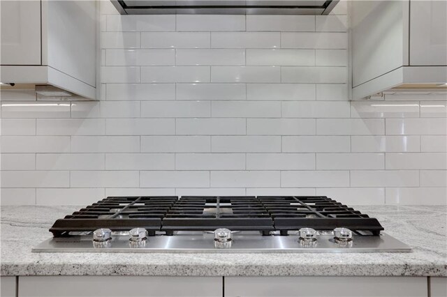 2620 Middle Coray Cir, Marietta, GA 30066 - details featuring stainless steel gas cooktop, range hood, white cabinetry, and tasteful backsplash