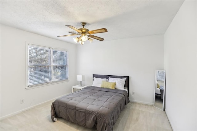 bedroom with ceiling fan and a textured ceiling