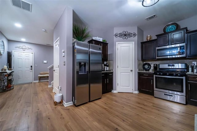 kitchen with visible vents, light wood-style flooring, stainless steel appliances, and baseboards