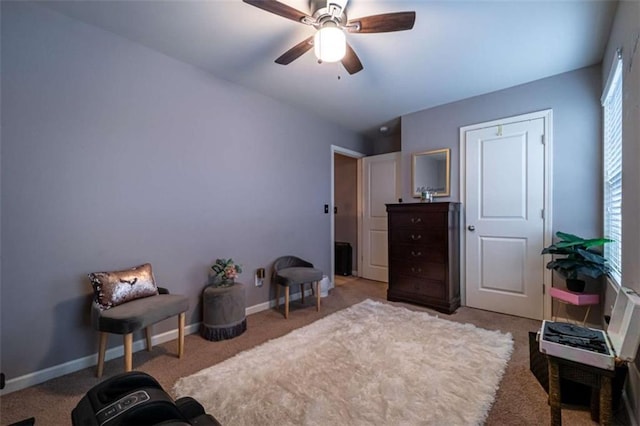 living area featuring baseboards and ceiling fan