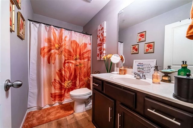 bathroom with vanity, a shower with curtain, toilet, and wood finished floors