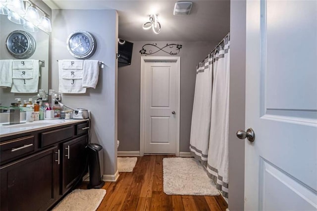 full bath featuring vanity, baseboards, and wood finished floors