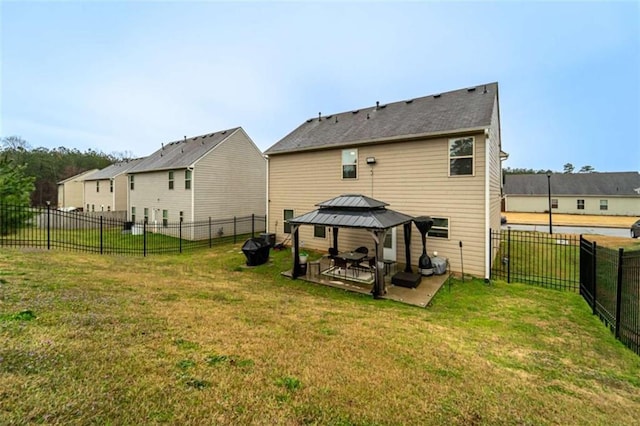 rear view of house featuring a gazebo, a residential view, a lawn, and a fenced backyard