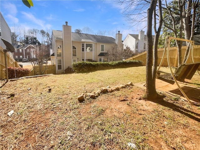 rear view of property with fence and a chimney