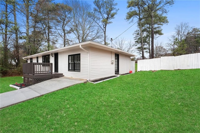 view of side of home with a wooden deck and a yard