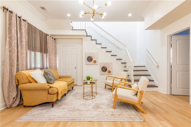 living area with an inviting chandelier, crown molding, and wood-type flooring