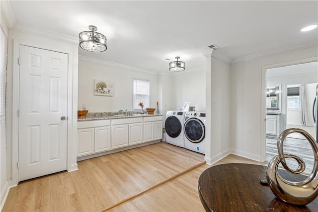 washroom with separate washer and dryer, light hardwood / wood-style floors, sink, plenty of natural light, and crown molding