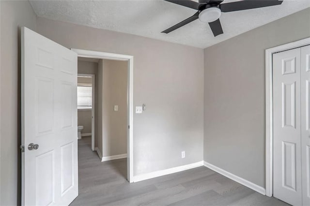 2945 Catalina Dr, Decatur, GA 30032 - unfurnished bedroom featuring a textured ceiling, wood finished floors, a ceiling fan, and baseboards