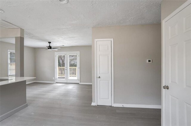 2945 Catalina Dr, Decatur, GA 30032 - spare room featuring baseboards, ceiling fan, wood finished floors, a textured ceiling, and french doors