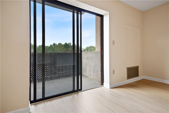 spare room with plenty of natural light and light hardwood / wood-style flooring