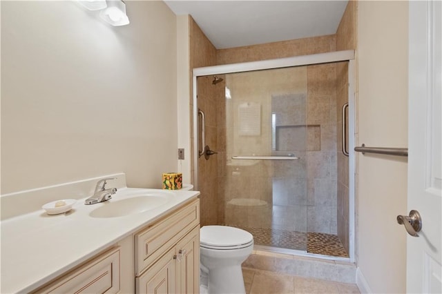 bathroom with tile patterned floors, vanity, toilet, and walk in shower