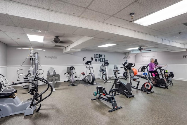 gym featuring ceiling fan and a drop ceiling