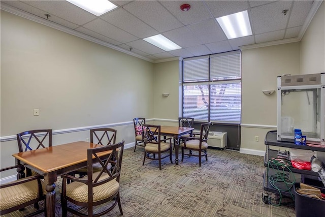 dining area with carpet flooring, a drop ceiling, and crown molding