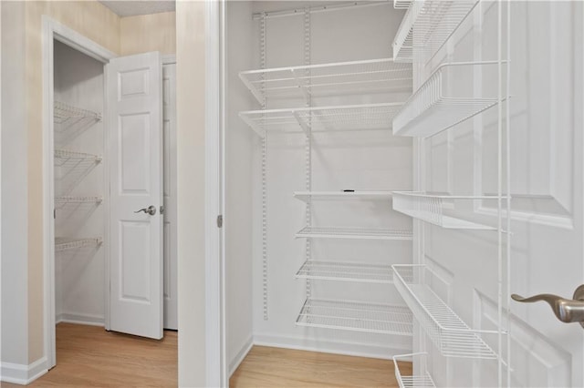 spacious closet featuring hardwood / wood-style floors