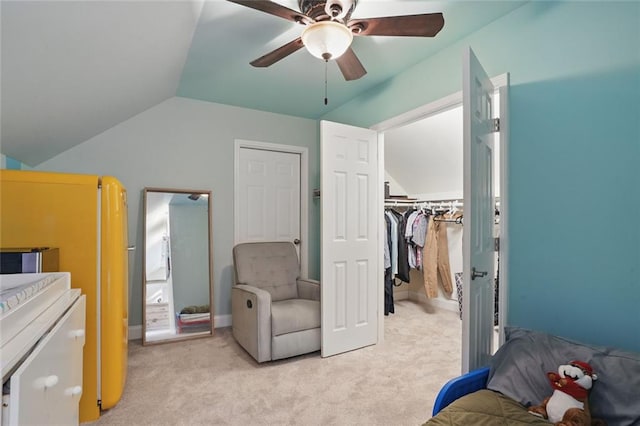 bedroom featuring lofted ceiling, light colored carpet, a closet, and a ceiling fan