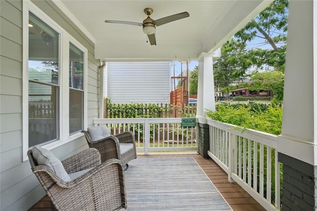 deck with covered porch and a ceiling fan