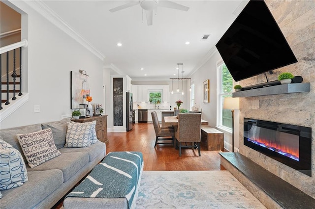 2610 Cheney St, East Point, GA 30344 - living room with wood finished floors, ornamental molding, a glass covered fireplace, stairs, and recessed lighting
