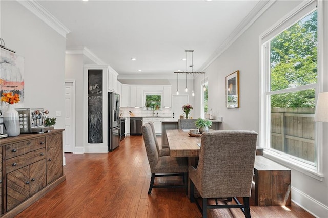 dining room featuring dark wood-type flooring, crown molding, baseboards, and recessed lighting