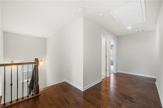 interior space with attic access, baseboards, and wood-type flooring