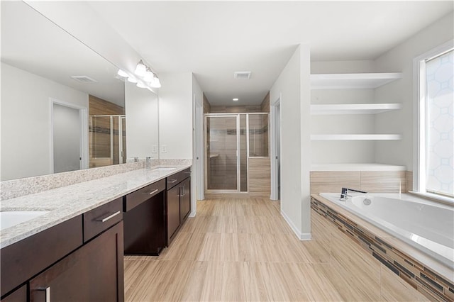 full bath featuring a sink, visible vents, a shower stall, and double vanity