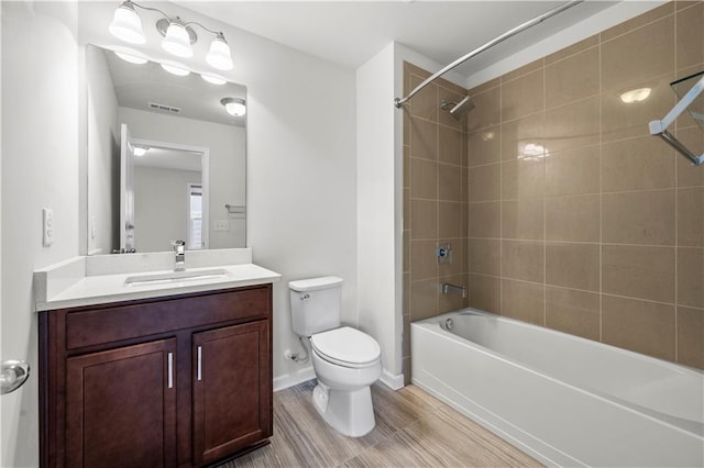 full bath featuring visible vents, shower / washtub combination, toilet, wood finished floors, and vanity