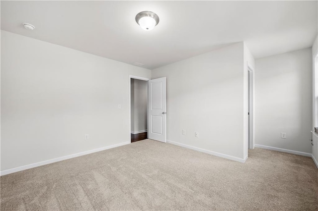 carpeted spare room featuring baseboards