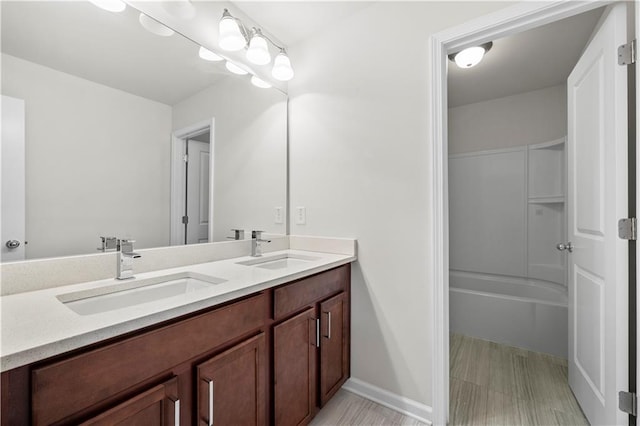 bathroom featuring a sink, baseboards, and double vanity