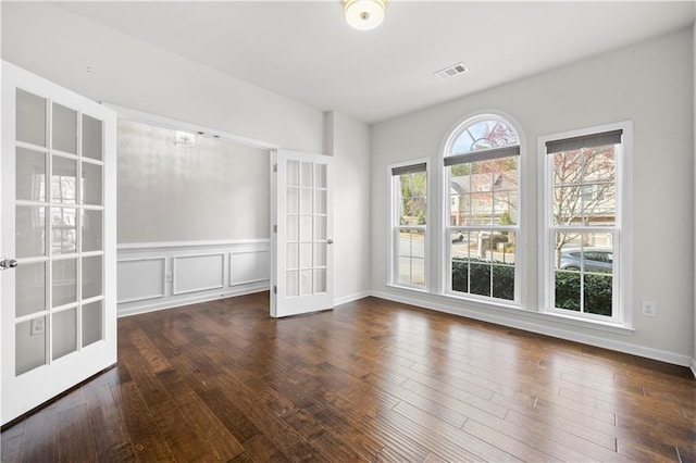 empty room featuring visible vents, wood-type flooring, and french doors