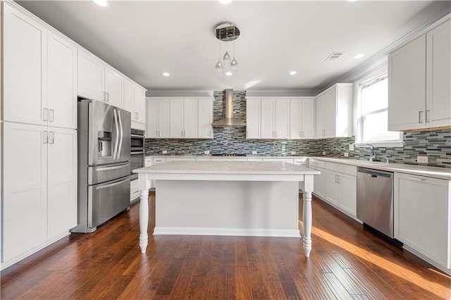 kitchen with a breakfast bar area, wall chimney exhaust hood, dark wood-style flooring, and stainless steel appliances