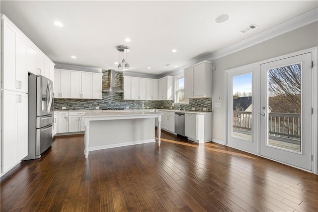 kitchen with visible vents, dark wood-style flooring, stainless steel appliances, light countertops, and wall chimney range hood