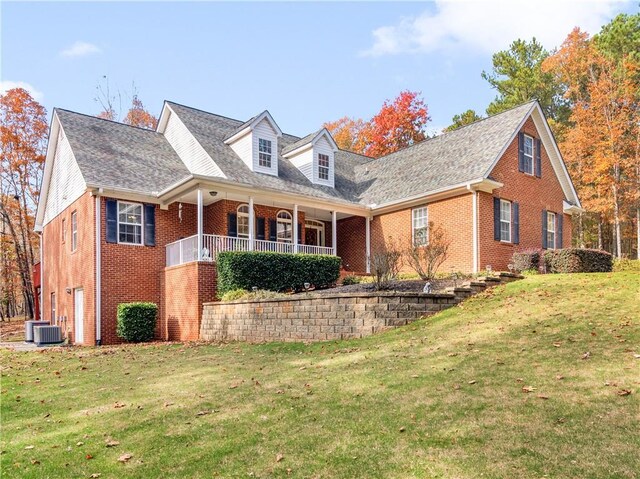 view of front of property with a porch, a front lawn, and central air condition unit