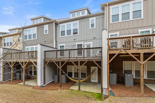1098 Caruso Dr, Buford, GA 30518 - rear view of house featuring board and batten siding, central AC unit, and a wooden deck