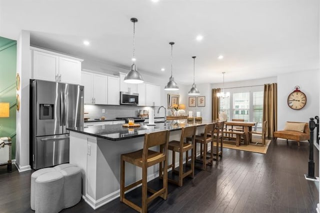 1098 Caruso Dr, Buford, GA 30518 - kitchen featuring white cabinets, stainless steel appliances, a kitchen breakfast bar, and a large island with sink