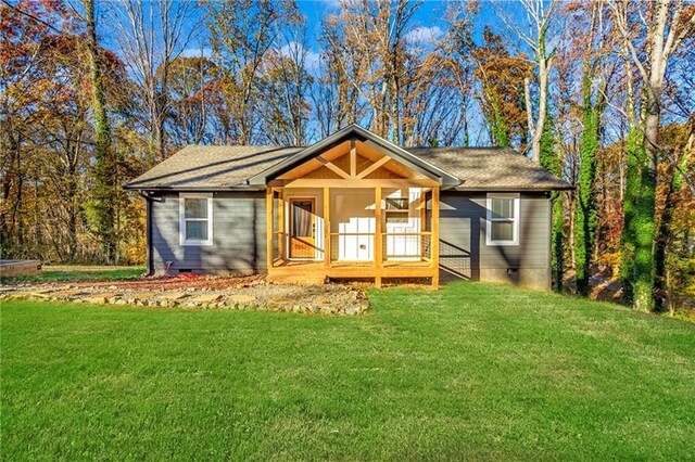 view of front of house with a front lawn and a sunroom