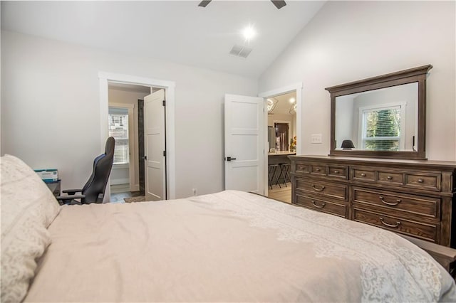 bedroom featuring ceiling fan, ensuite bathroom, and lofted ceiling