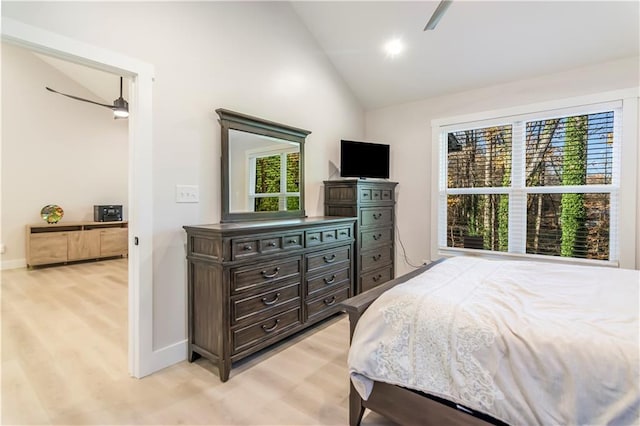 bedroom featuring ceiling fan, multiple windows, light hardwood / wood-style flooring, and lofted ceiling