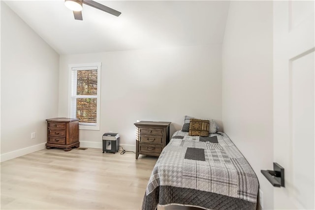 bedroom featuring ceiling fan, light wood-type flooring, and vaulted ceiling