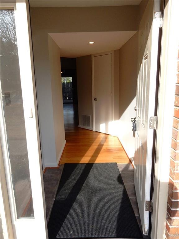 corridor with hardwood / wood-style flooring