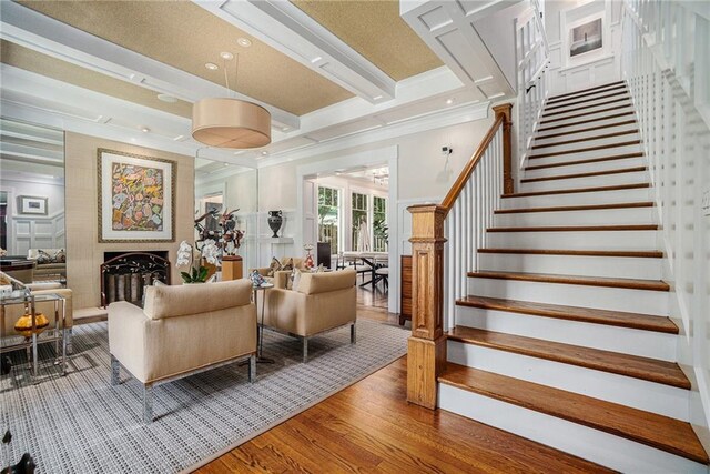 1634 Lenox Rd NE, Atlanta, GA 30306 - living room featuring light wood finished floors, ornamental molding, a fireplace with raised hearth, and stairs