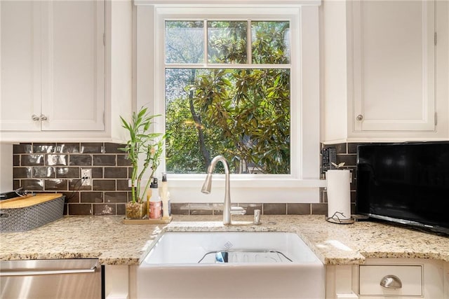 1634 Lenox Rd NE, Atlanta, GA 30306 - interior details featuring white cabinets, a sink, backsplash, stainless steel dishwasher, and light stone counters