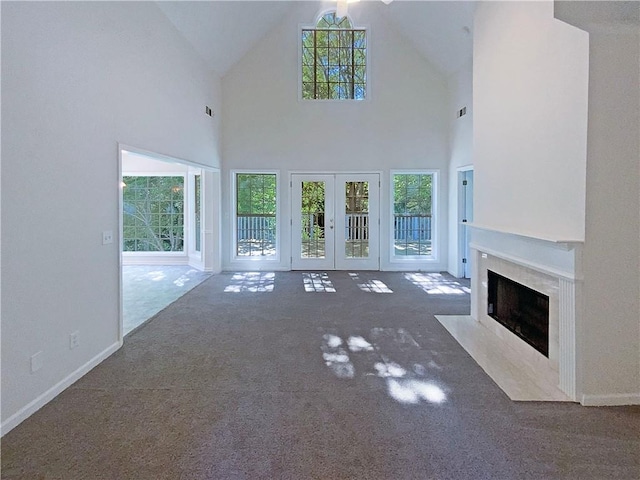 132 Lynnview Ct, Mcdonough, GA 30252 - unfurnished living room with a high end fireplace, plenty of natural light, carpet, french doors, and high vaulted ceiling
