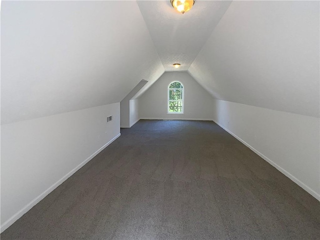 132 Lynnview Ct, Mcdonough, GA 30252 - additional living space with vaulted ceiling, dark carpet, and baseboards