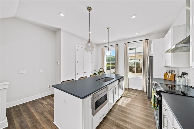 1247 Zucchini Cir SE, Atlanta, GA 30315 - kitchen with stainless steel appliances, dark countertops, a sink, white cabinetry, and wall chimney range hood