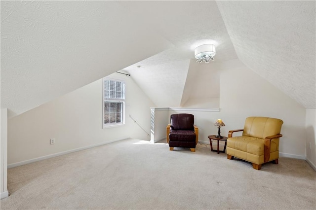 sitting room featuring an upstairs landing, lofted ceiling, a textured ceiling, carpet flooring, and baseboards